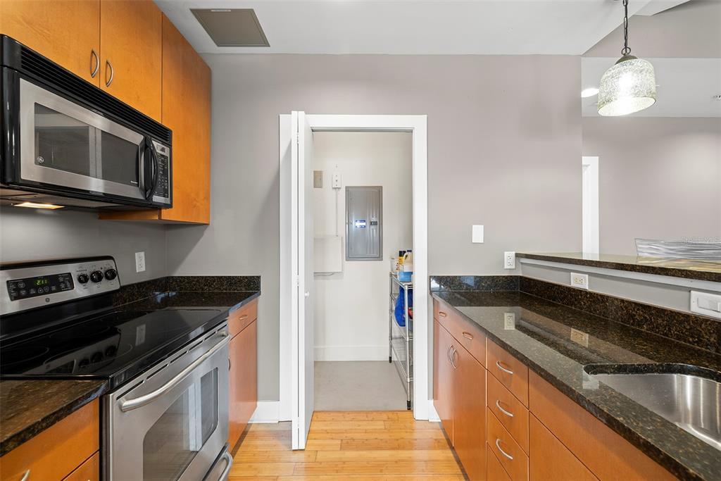 1010 Central Avenue, Unit 302 St. Petersburg, FL 33705 - Photo 14 of 50 a kitchen with stainless steel appliances granite countertop a stove and a microwave