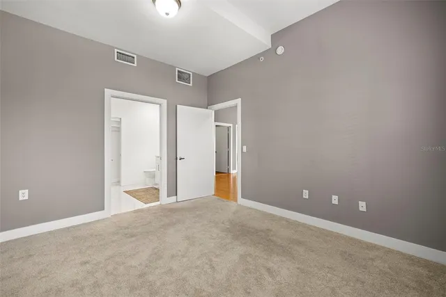 a spacious bathroom with a double vanity sink a toilet and a mirror