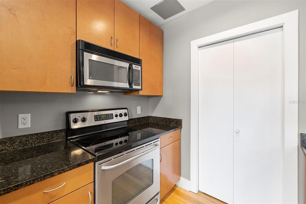 1010 Central Avenue, Unit 302 St. Petersburg, FL 33705 - Photo 10 of 50 a kitchen with granite countertop cabinets stainless steel appliances and a counter space