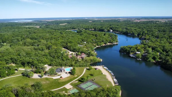 an aerial view of a house with a yard lake house and outdoor seating