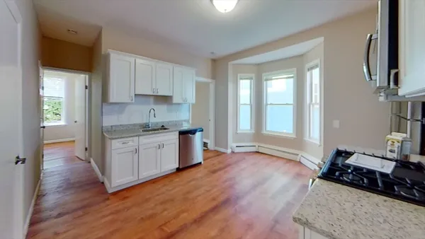 a kitchen with a sink wooden floor and a window