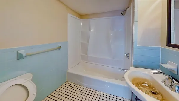 a bathroom with a granite countertop bathtub sink mirror vanity and toilet