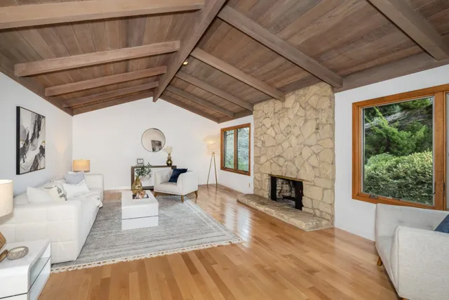 a living room with furniture fireplace and a large window