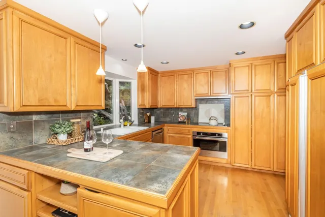 a kitchen with stainless steel appliances granite countertop a sink a stove and a refrigerator