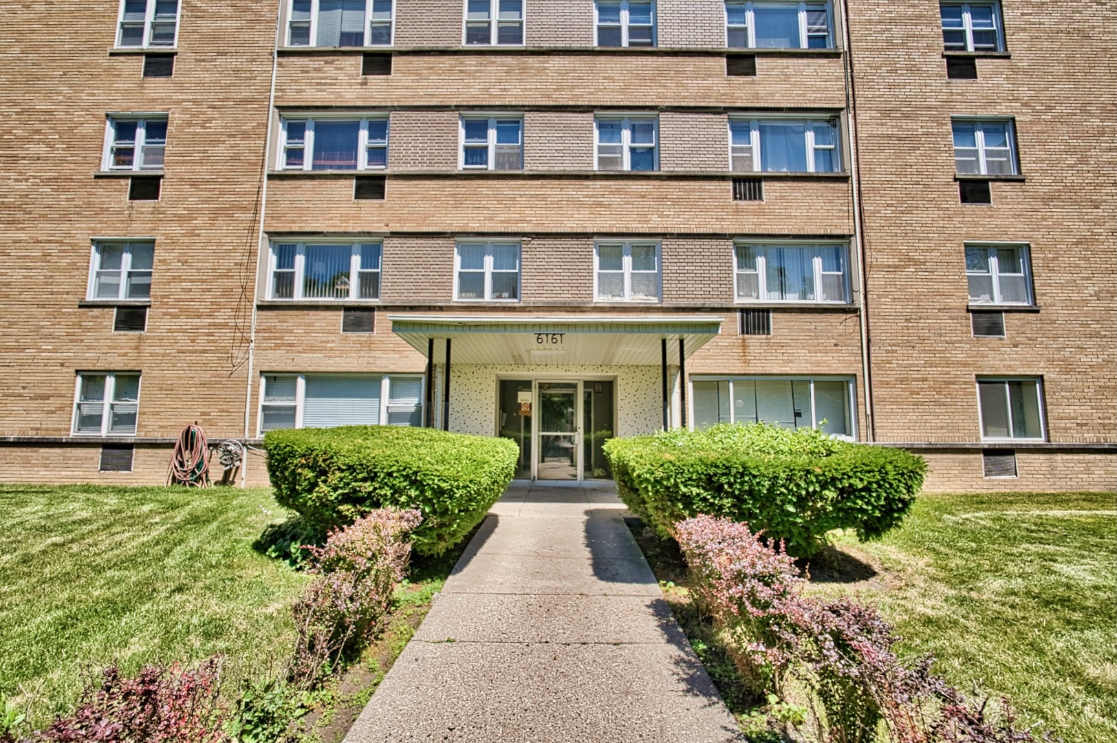 6161 North Hoyne Avenue, Unit 414 Chicago, IL 60659 - Photo 11 of 11 front view of a brick house with a yard