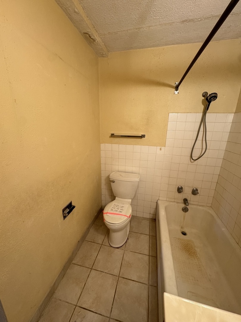 6161 North Hoyne Avenue, Unit 414 Chicago, IL 60659 - Photo 6 of 11 a bathroom with a granite countertop toilet and a shower