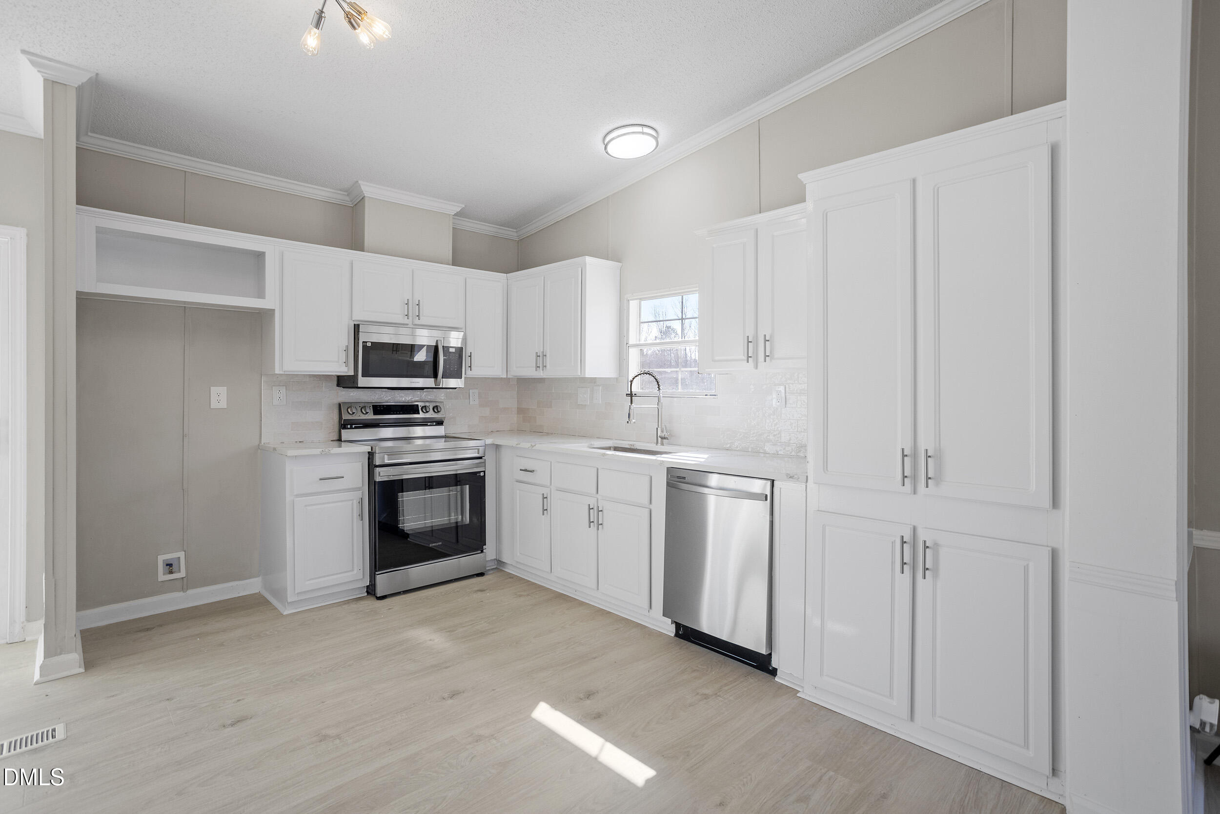 10965 Beaver Dam Road Middlesex, NC 27557 - Photo 3 of 24 a kitchen with white cabinets and white appliances