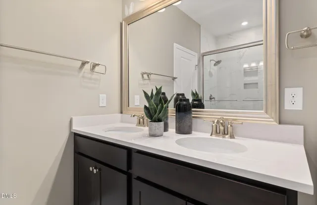 a bathroom with a double vanity sink a mirror and shower