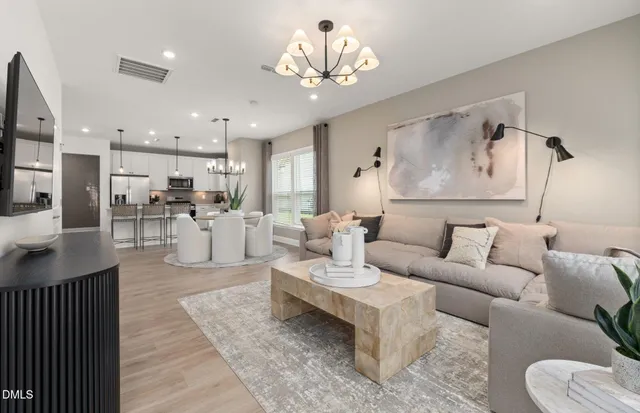 a living room with fireplace furniture and a chandelier