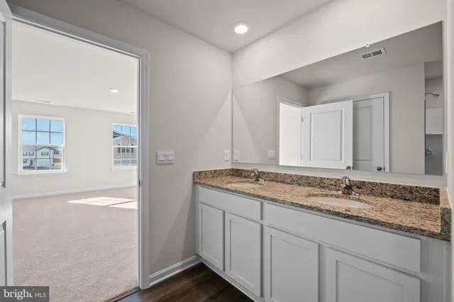 a bathroom with a granite countertop sink and a mirror