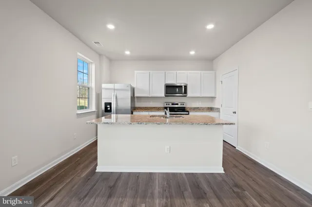 a kitchen with stainless steel appliances granite countertop a refrigerator a stove top oven a sink and dishwasher