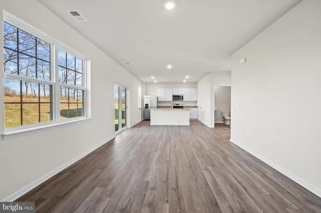 a view of a living room hardwood floor and a kitchen