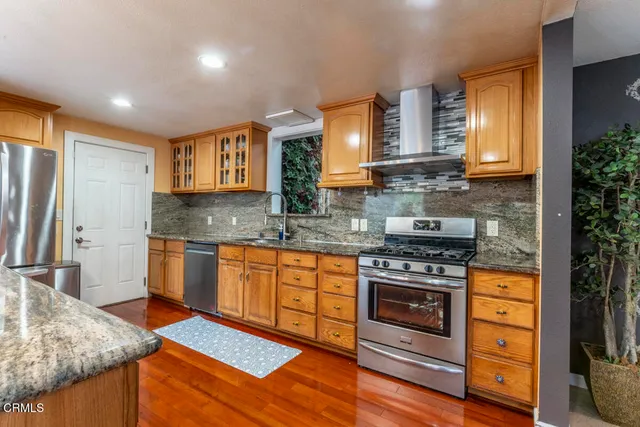 a kitchen with stainless steel appliances granite countertop a stove a sink and a microwave