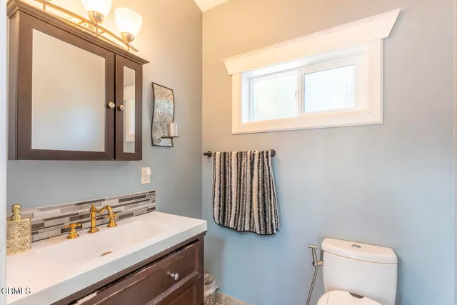 a bathroom with a sink a toilet and mirror