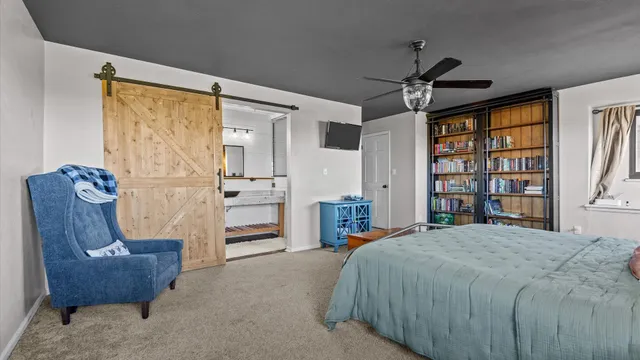 a spacious bedroom with a bed and a chair