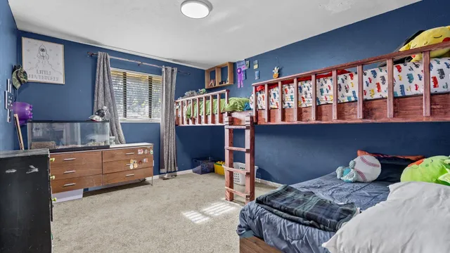 a bedroom with a bunk bed and a window