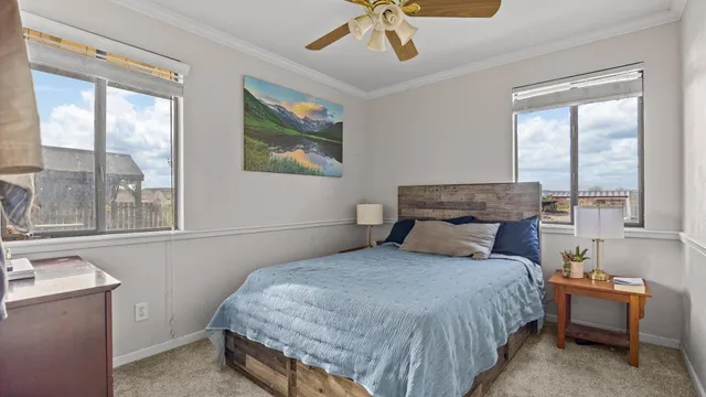 a bedroom with a bed and large windows