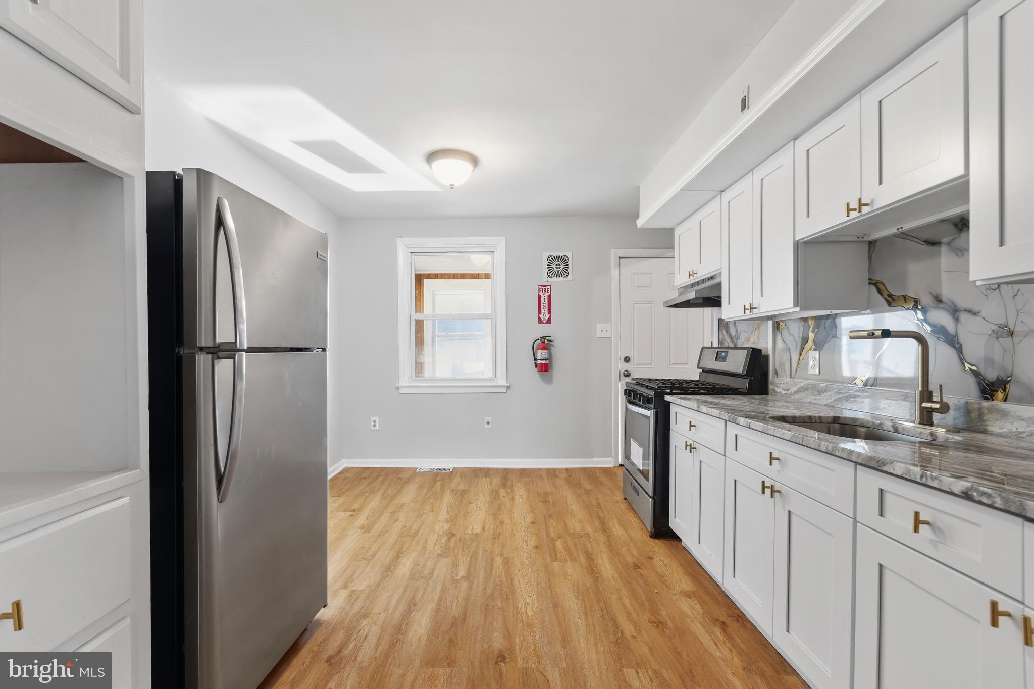 129 Brown Street Mount Holly, NJ 08060 - Photo 5 of 19 a kitchen with a refrigerator a sink and dishwasher with wooden floor