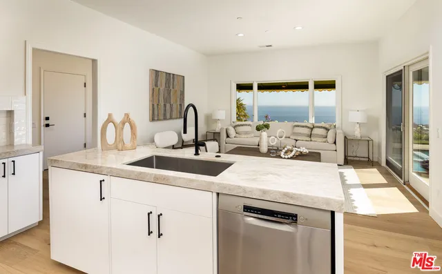 a kitchen with kitchen island a sink appliances and cabinets