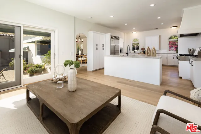 a kitchen with stainless steel appliances granite countertop sink wooden floor and glass top table