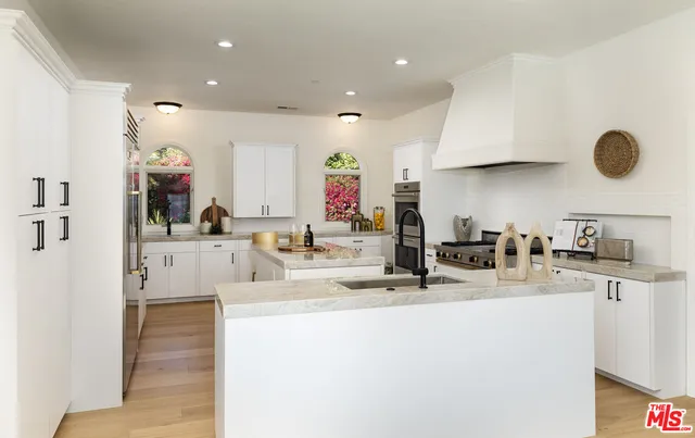 a kitchen with stainless steel appliances granite countertop a sink and a refrigerator