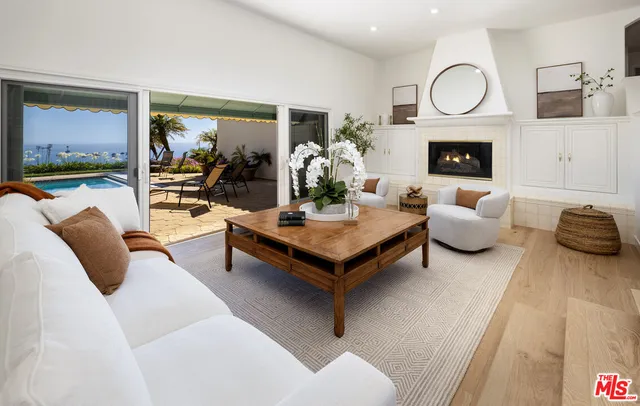 a living room with furniture fireplace and a large window