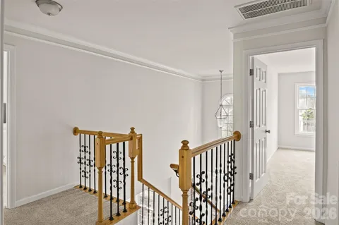 a view of a hallway with wooden floor and windows