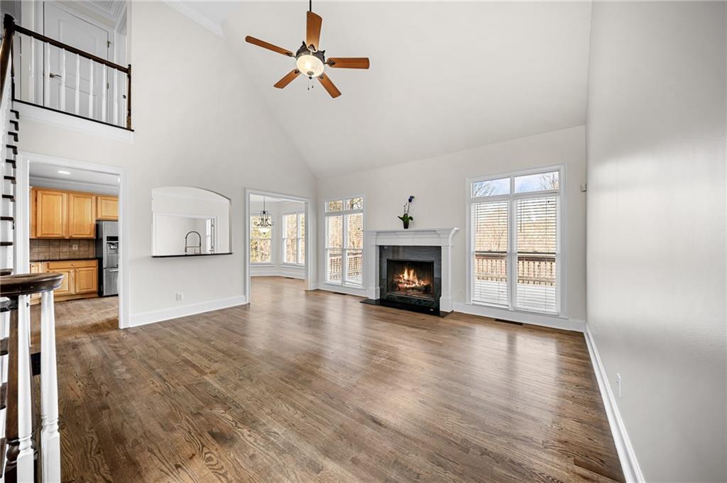 8805 Saddle Trail Ball Ground, GA 30107 - Photo 15 of 53 an empty room with windows fireplace and wooden floor