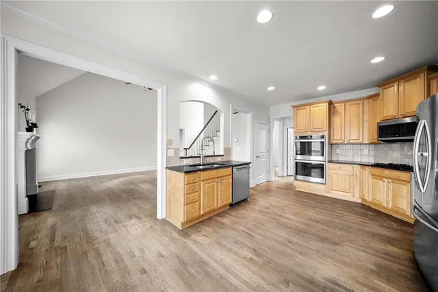 a view of a room with wooden floor chandeliers and kitchen