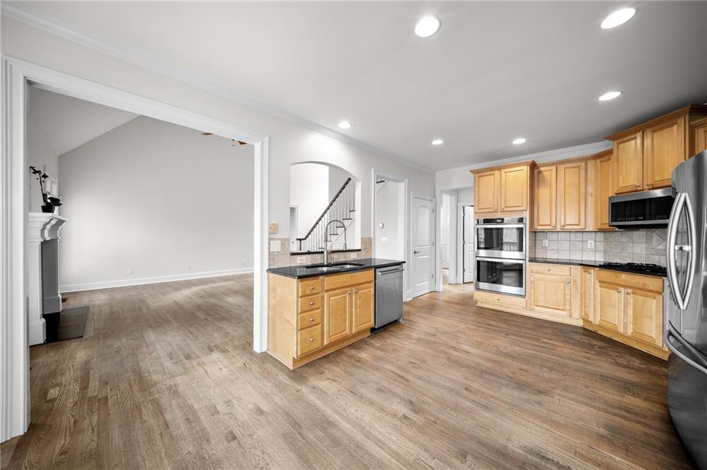 8805 Saddle Trail Ball Ground, GA 30107 - Photo 17 of 53 a kitchen with stainless steel appliances granite countertop a stove a sink and a refrigerator