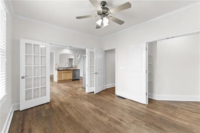 a view of a hallway with wooden floor and a kitchen