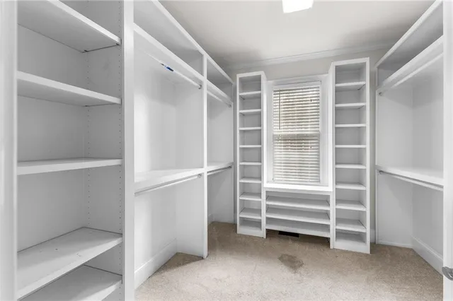 a view of a livingroom with wooden floor a fireplace a ceiling fan and a window