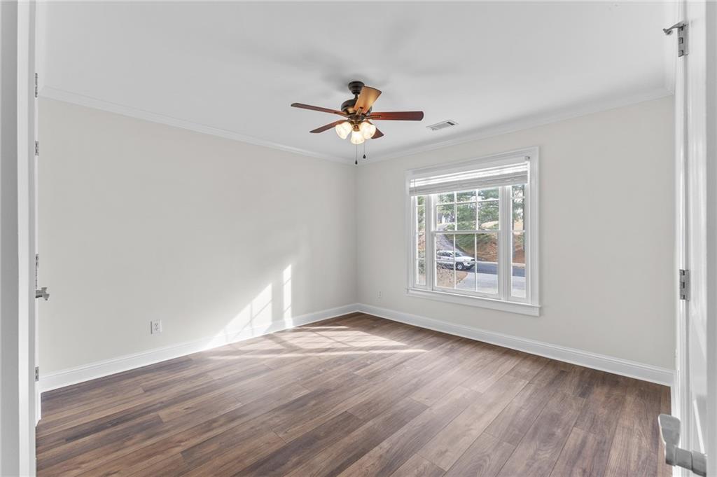 8805 Saddle Trail Ball Ground, GA 30107 - Photo 46 of 53 an empty room with wooden floor chandelier fan and windows