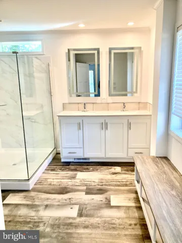 a bathroom with a tub a mirror and a shower