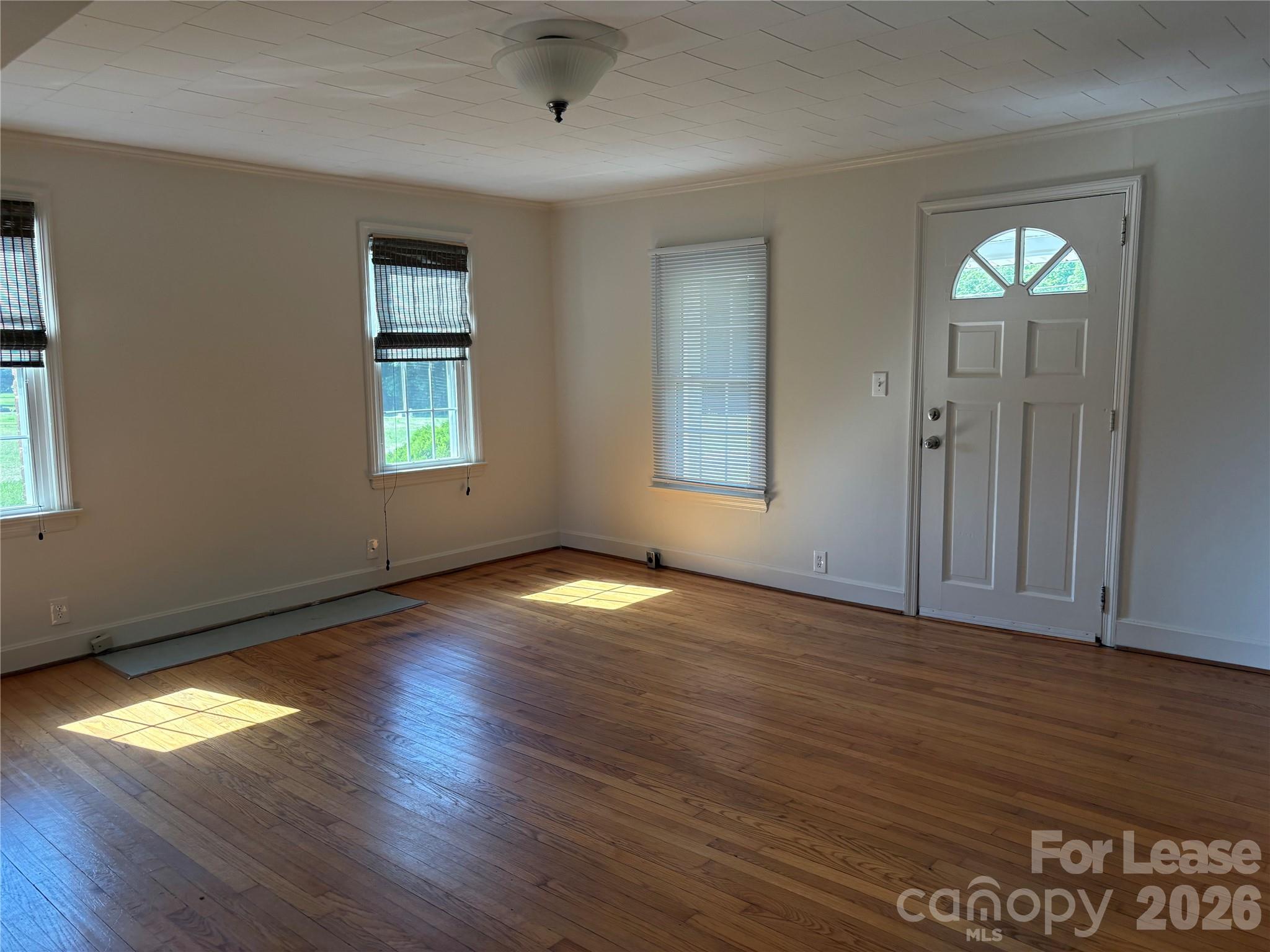 6625 Long Road Matthews, NC 28104 - Photo 6 of 21 an empty room with wooden floor and windows