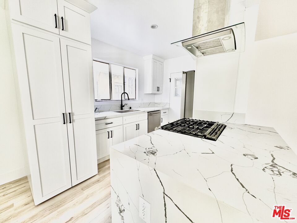 121 South Crescent Drive, Unit D Beverly Hills, CA 90212 - Photo 4 of 10 a kitchen with cabinets and white appliances