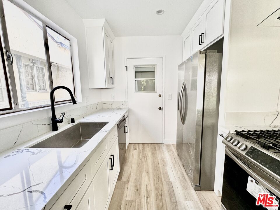 121 South Crescent Drive, Unit D Beverly Hills, CA 90212 - Photo 5 of 10 a kitchen with a sink stove and refrigerator