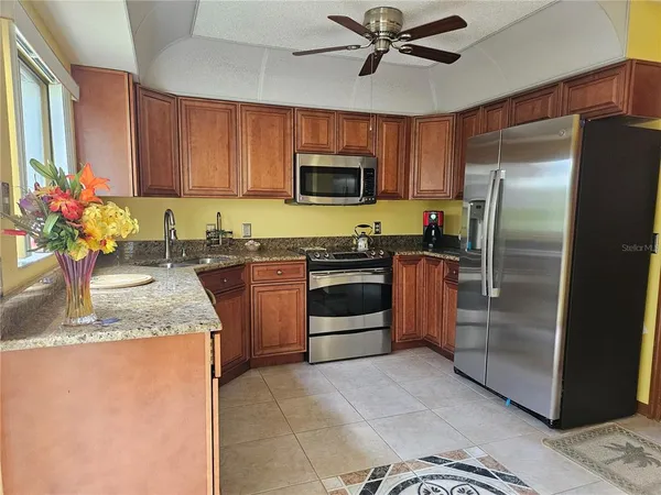 a kitchen with stainless steel appliances granite countertop a refrigerator a stove a sink and dishwasher