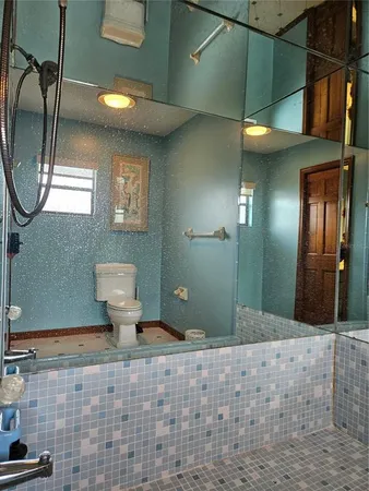 a bathroom with a toilet sink and mirror