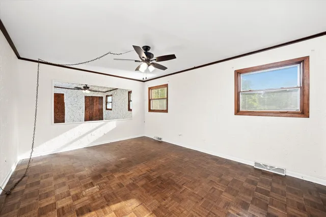 a view of a big room with wooden floor and windows