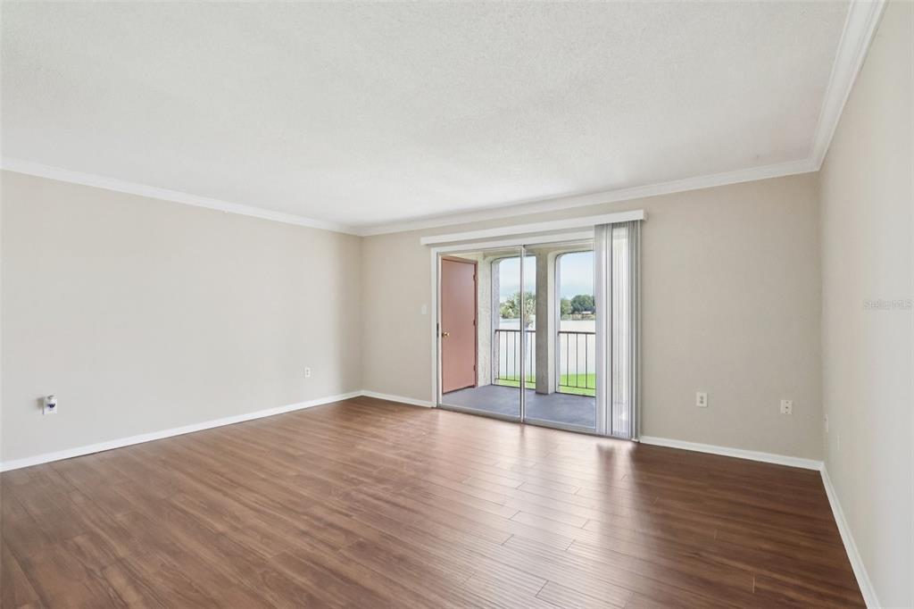 534 Orange Drive, Unit 27 Altamonte Springs, FL 32701 - Photo 4 of 24 a view of an empty room with wooden floor and window