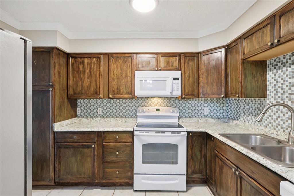 534 Orange Drive, Unit 27 Altamonte Springs, FL 32701 - Photo 6 of 24 a kitchen with a sink and a stove top oven