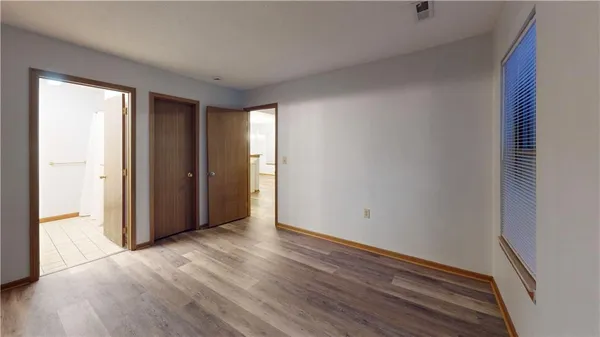 a view of an empty room with wooden floor