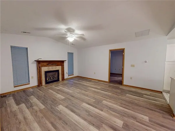 a view of empty room with fireplace and fan