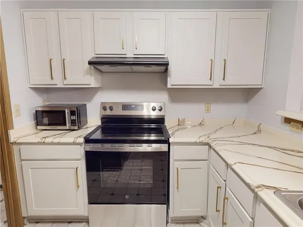 a stove top oven sitting inside of a kitchen
