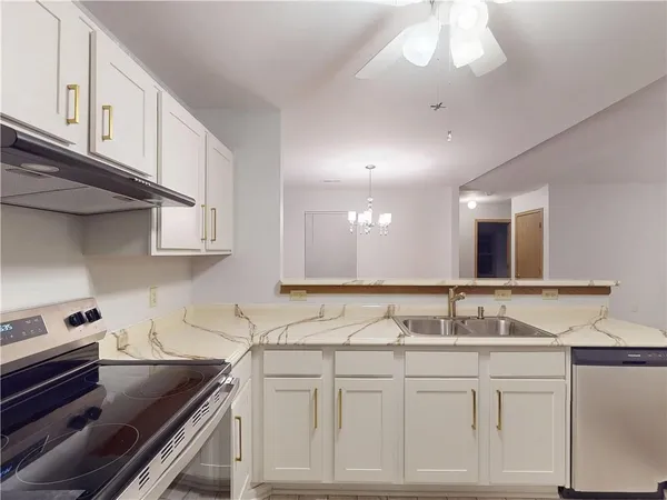 a kitchen with granite countertop a sink a stove and cabinets