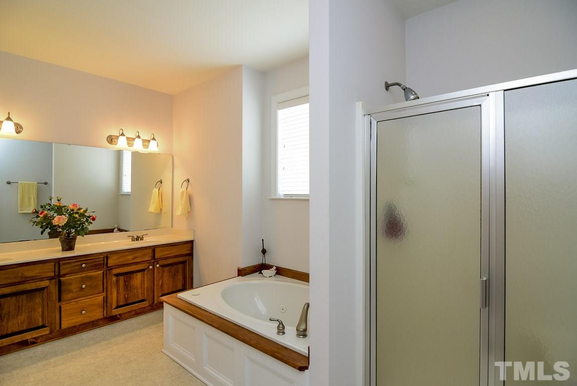 10933 Jordan Road Raleigh, NC 27603 - Photo 14 of 25 a en suite bathroom with a tub sink and mirror