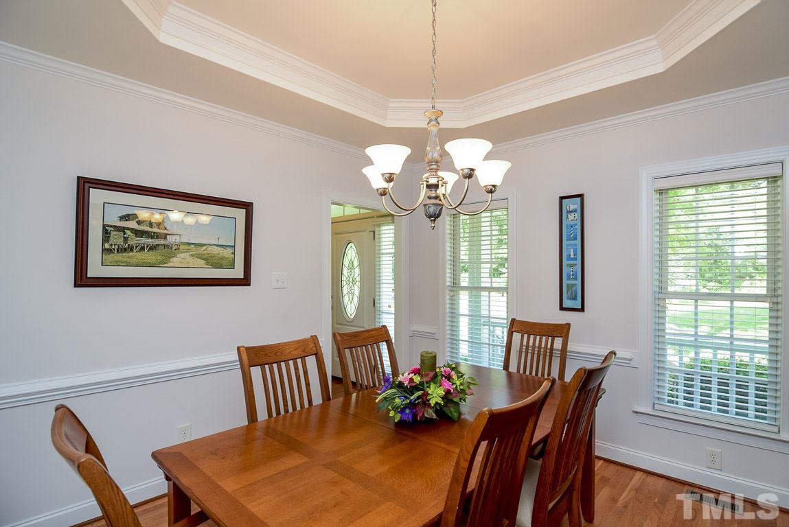 10933 Jordan Road Raleigh, NC 27603 - Photo 3 of 25 a view of a dining room with furniture a chandelier and wooden floor