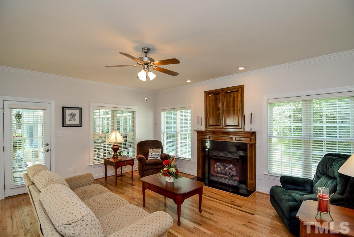 10933 Jordan Road Raleigh, NC 27603 - Photo 5 of 25 a living room with furniture a fireplace a large window and a flat screen tv