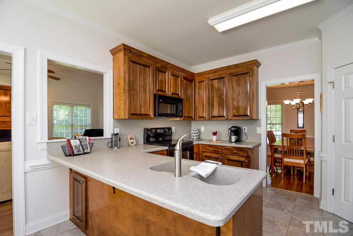 10933 Jordan Road Raleigh, NC 27603 - Photo 8 of 25 a kitchen with a sink a stove and chairs